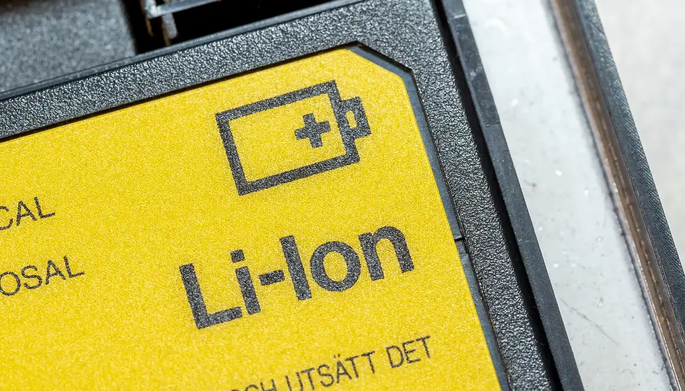 Yellow lithium-ion battery label with a battery icon and text "Li-Ion" in black. The label is textured and part of a device.