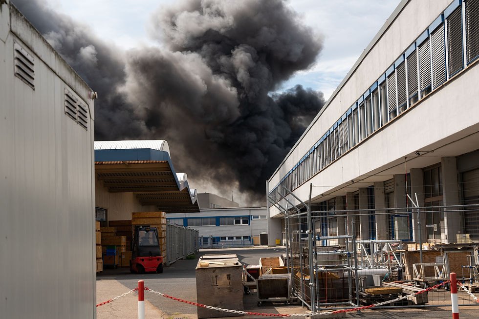 Thick black smoke rising from an industrial site due to lithium battery fires, highlighting the dangers and risk management challenges associated with hazardous materials in storage or transit.