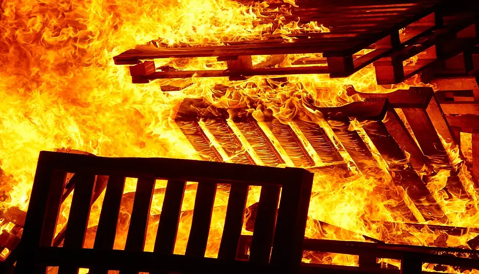 Wooden pallets ablaze in a large fire, highlighting the risks associated with improper storage of combustible materials.