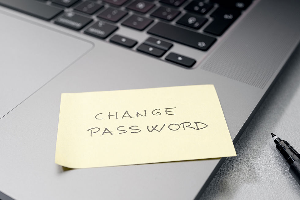 Laptop keyboard with post it note reminder saying 'change password'