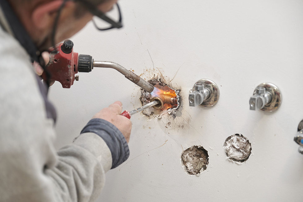 Plumber using blow torch on piping in building